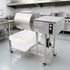 Commercial electric meat marinator placed in a professional stainless steel kitchen setting. Automatic food tumbling machine ready for restaurant food processing.