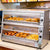 Commercial 2-tier heated display cabinet filled with fried chicken and burgers for fast food restaurants.