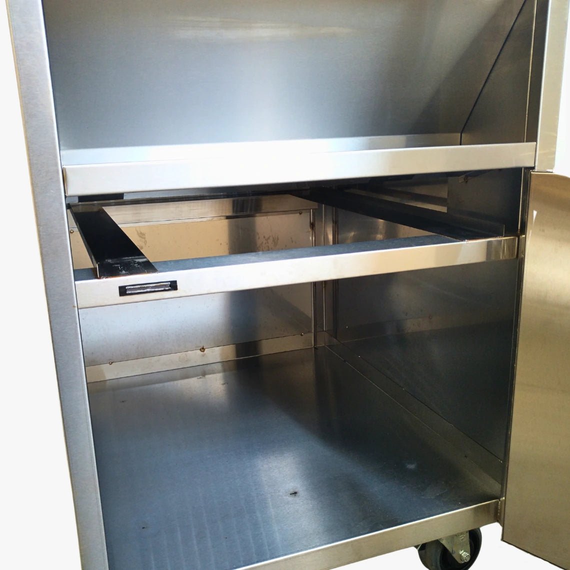 Spacious interior storage cabinet base of the commercial fry station, perfect for storing extra paper bags and kitchen supplies.