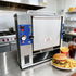 Commercial Vertical Toaster in Fast Food Kitchen Setting next to Burger and Fries.